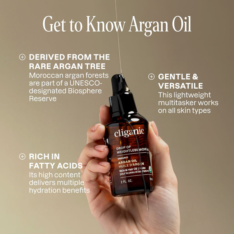 Hand holding a bottle of Cliganic Argan Oil with text about argan oil on a beige background