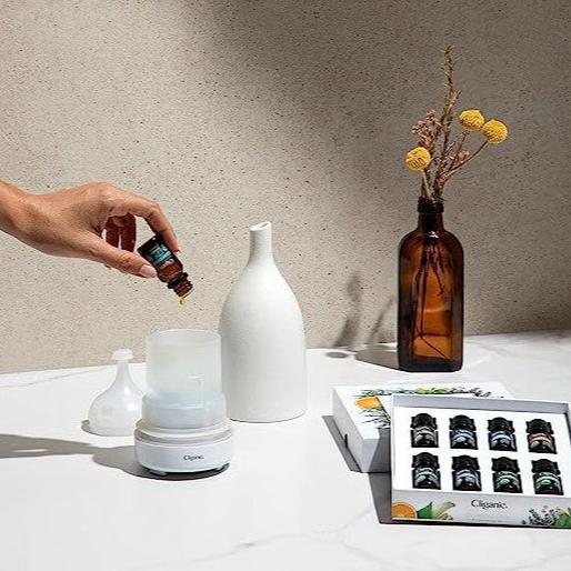 Cliganic ceramic ultrasonic diffuser with essential oil bottle and boxed aromatherapy set in a calm, minimalist home setting.