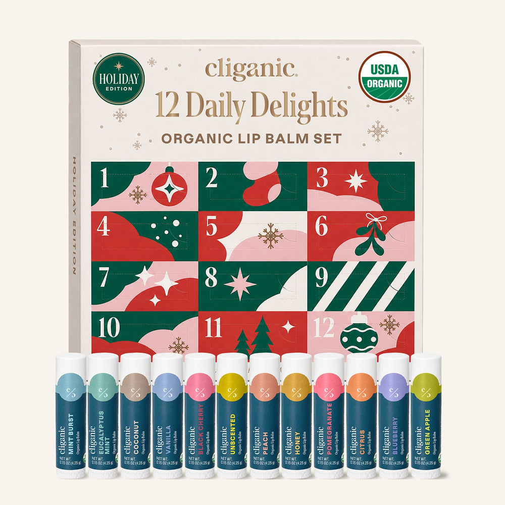 Cliganic 12 Daily Delights Organic Lip Balm Set holiday edition box with 12 individual lip balm tubes lined up in front on a light cream background.
