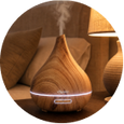 Wooden essential oil diffuser releasing aromatic mist in a cozy home setting
