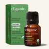 Cliganic laurel organic essential oil bottle next to green packaging on a neutral background.