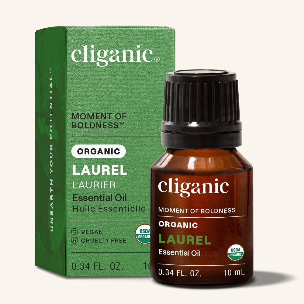 Cliganic laurel organic essential oil bottle next to green packaging on a neutral background.